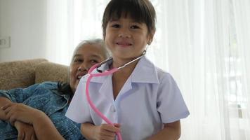 Little Girl Dressed As A Doctor Plays With Grandma video