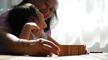 grand-mère et petite-fille jouent avec des blocs jenga video