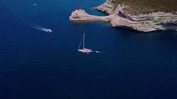 Drone follows a yacht in a bay in 4K video