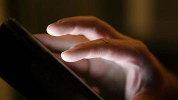 mains touchant l'écran d'une tablette video