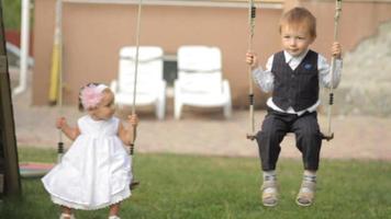 garçon et fille sur les balançoires video