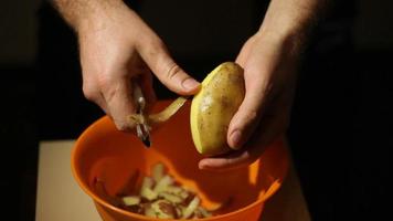 mãos descascando uma batata video