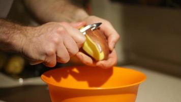 Hände schälen eine Kartoffel