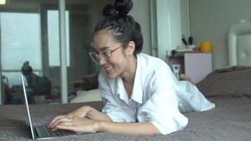 junge asiatische Frau, die mit einem Laptop arbeitet video