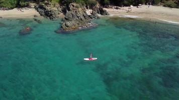 garota paddle boarding no mar em 4k video