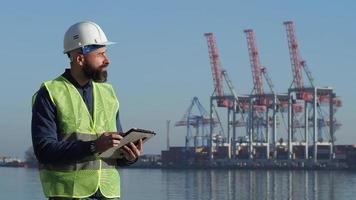 trabajador portuario trabajando con una tableta video