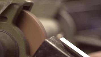 A carpenter grinds a chisel on a grinder video