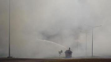 les camions de pompiers aspergent de l'eau lors des incendies de forêt et de la fumée, video