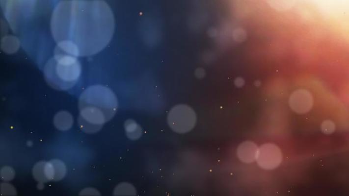 Abstract defocused blur bokeh particles dropping on blue and orange color  background.