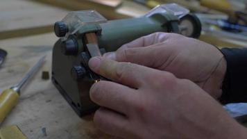 Close-up, worker sharpening a chisel on a grindstone, sparks video