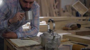 Toma panorámica del hombre bebiendo café o té mientras toma notas video