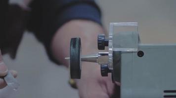 close-up de mãos afiando uma faca de metal em uma máquina de amolar video