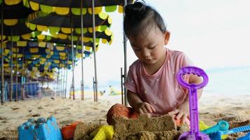Aziatische babymeisje spelen met strand speelgoed