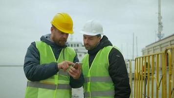 två arbetande män diskuterar ett projekt via telefon video