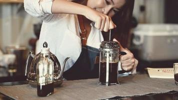 asiatische weibliche Barista, die Kaffee mit einer französischen Presse kocht video