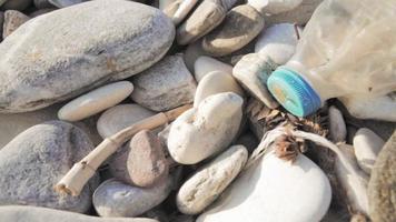 en plastflaska på en stenig strand