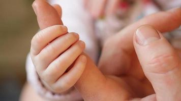 Hand der kleinen Tochter, die Papas großen Finger hält