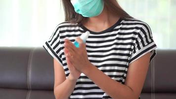 una mujer con una máscara y desinfectando sus manos video