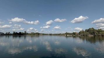 blauer bewölkter Himmel über einem Fluss und Bäumen video