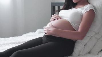 mujer embarazada sentada en el dormitorio. video