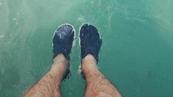 Man's feet in the sea  video