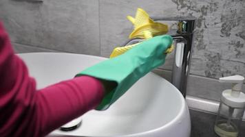 Woman Cleans a Faucet with a Yellow Rag.  video