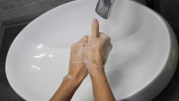 onherkenbaar persoon wast grondig zijn handen met antibacteriële zeep. video