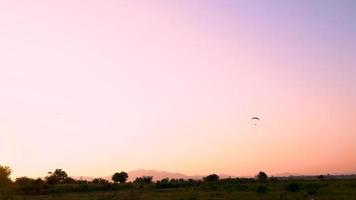 Paraglider flying in the sunset sky video
