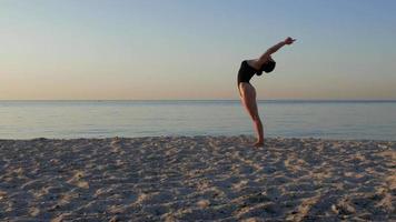 Athletic woman doing yoga exercises on the sand video