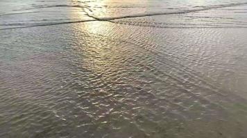 ondas do mar na praia durante o pôr do sol