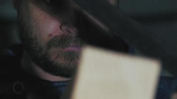 le visage d'un homme regardant une poutre en bois avec un carré métallique video