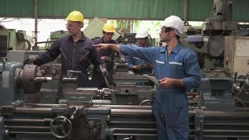 trabalhadores uniformizados inspecionam a área da linha de produção.