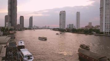 solnedgång vid chao phraya floden med utsikt över båtar och skyskrapa video