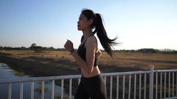 joven mujer asiática corriendo por el río video