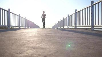 Young Asian Woman Jogging Over a Bridge video