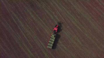 vista aérea de cima para baixo do drone de um trator vermelho em um campo em 4k video