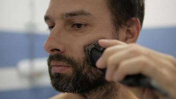 Bearded man shaving trimmer video