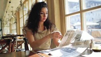 Frau, die eine Zeitung in einem Café liest video