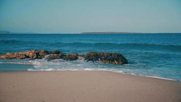 blauwgroen zeegolven breken op het strand