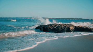 Transparent waves breaking on the rocks video