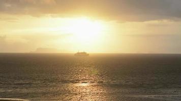El barco de pasajeros pasa por Koh Samui durante la puesta de sol. video