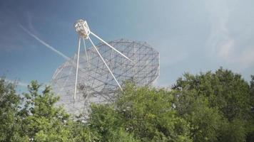 ein Radioteleskop, das hinter den Bäumen versteckt ist video