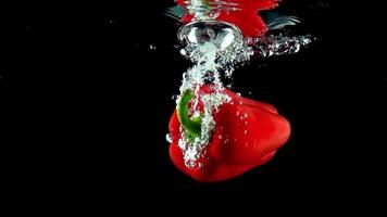 un peperone rosso che schizza in acqua limpida video