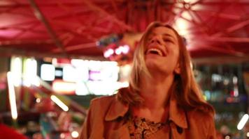 Portrait de femme regardant la caméra et riant dans le parc d'attractions