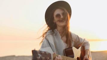 câmera lenta. linda garota tocando violão em um campo de trigo video