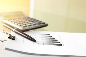 Soft focus of a pen and calculator with paperwork photo