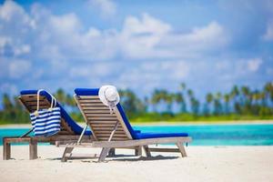 Two lounge chairs on a tropical beach photo