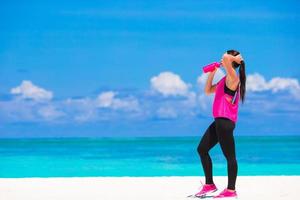 mujer bebiendo agua en un descanso para hacer ejercicio foto