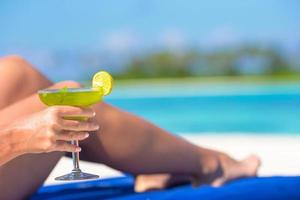 Close-up of a woman holding a cocktail at the beach photo