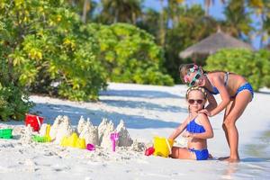 Two girls playing in the sand at a beach photo